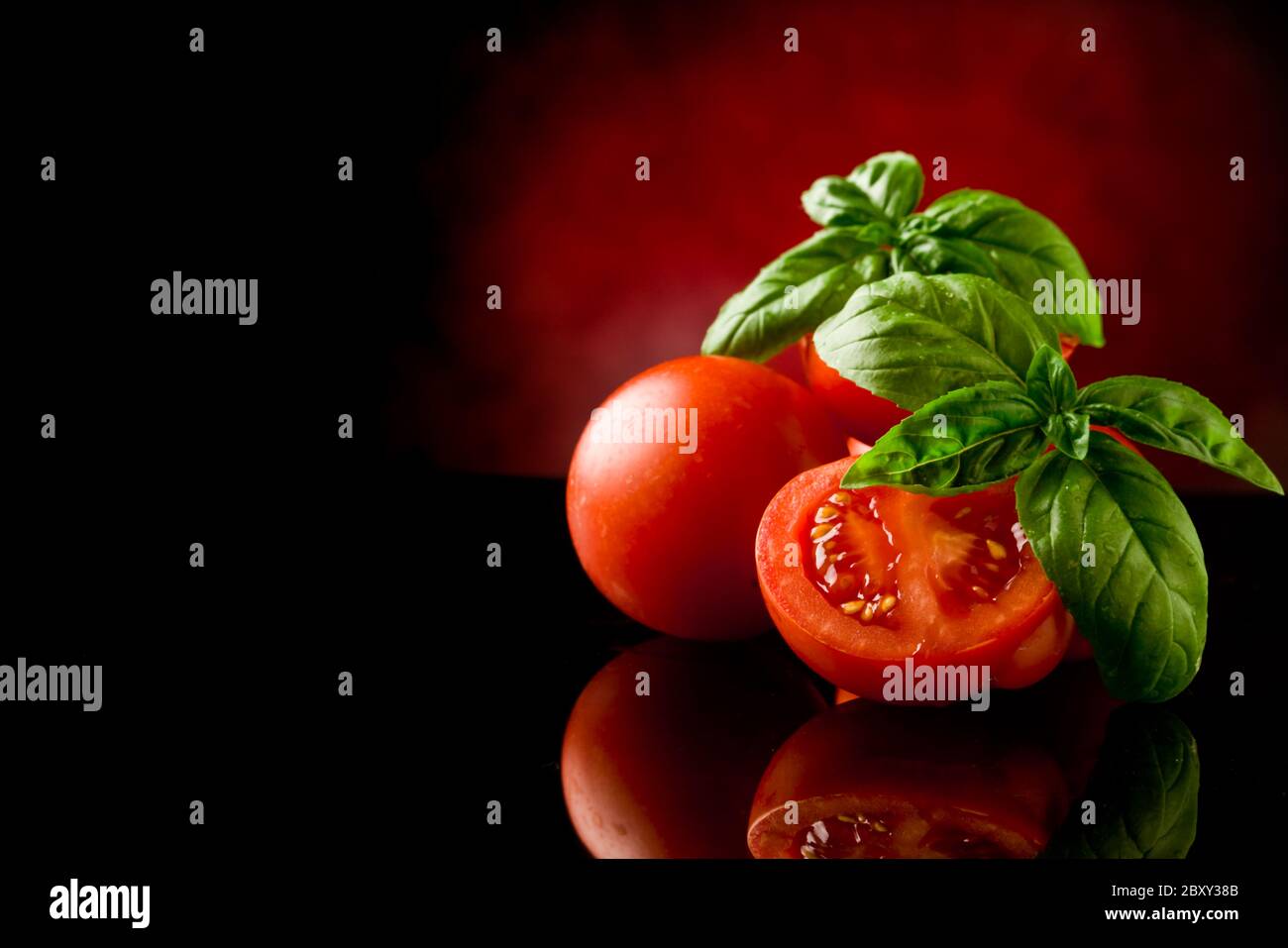 Sliced Tomatoes with basil on glass table Stock Photo - Alamy