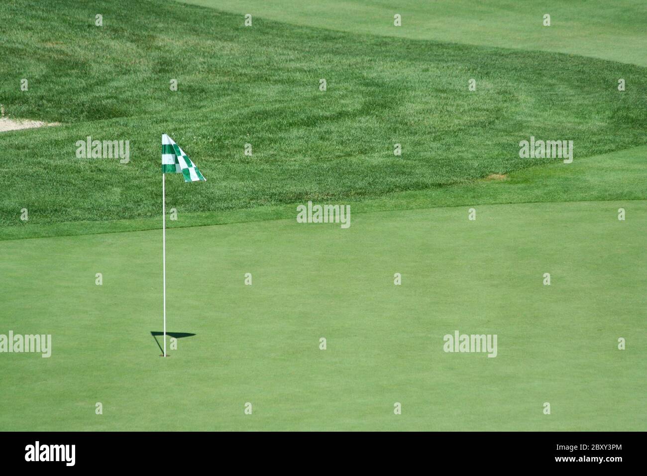 A green flag on a golf green Stock Photo