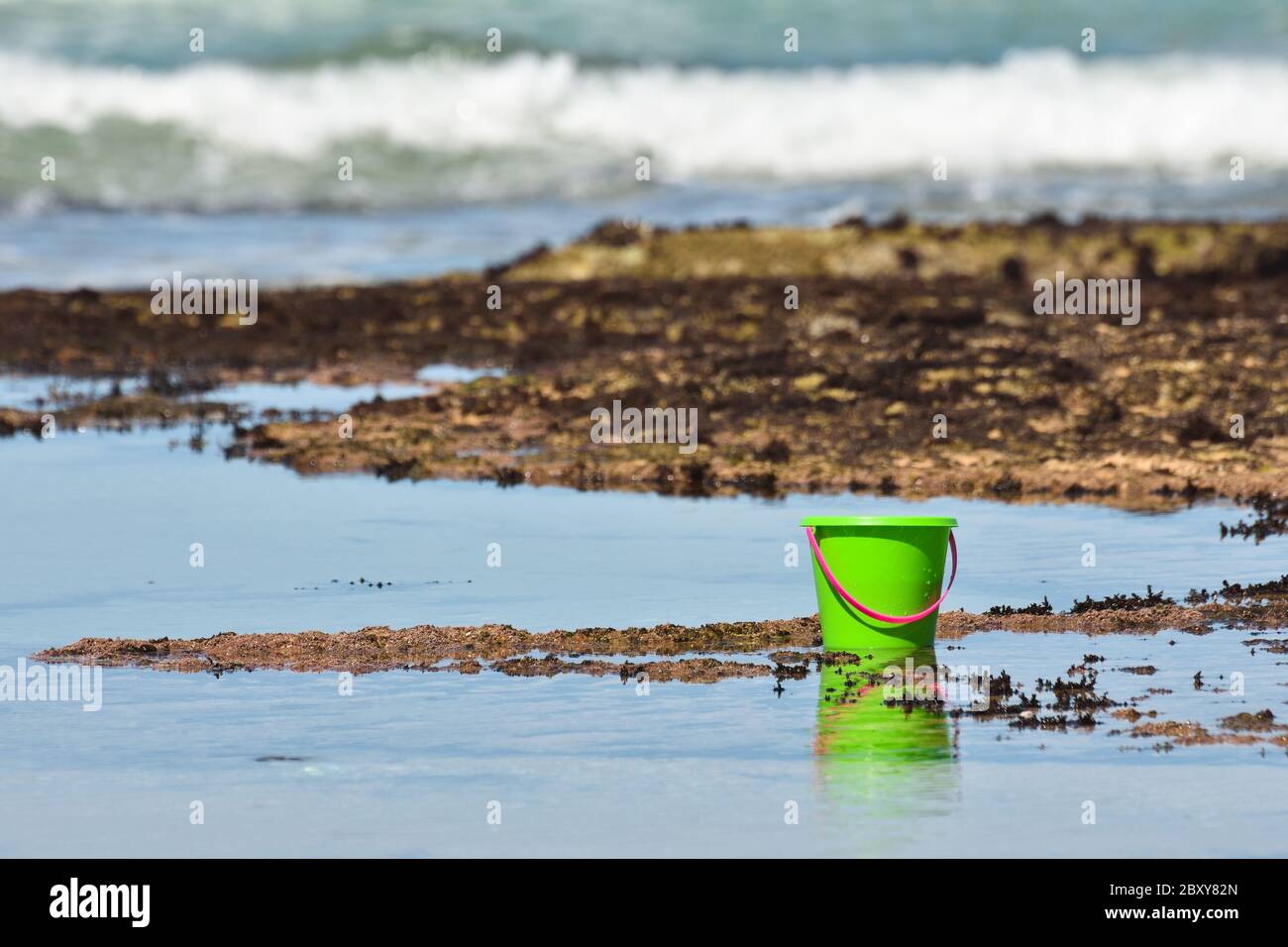 Bright Green Bucket By The Ocean Stock Photo