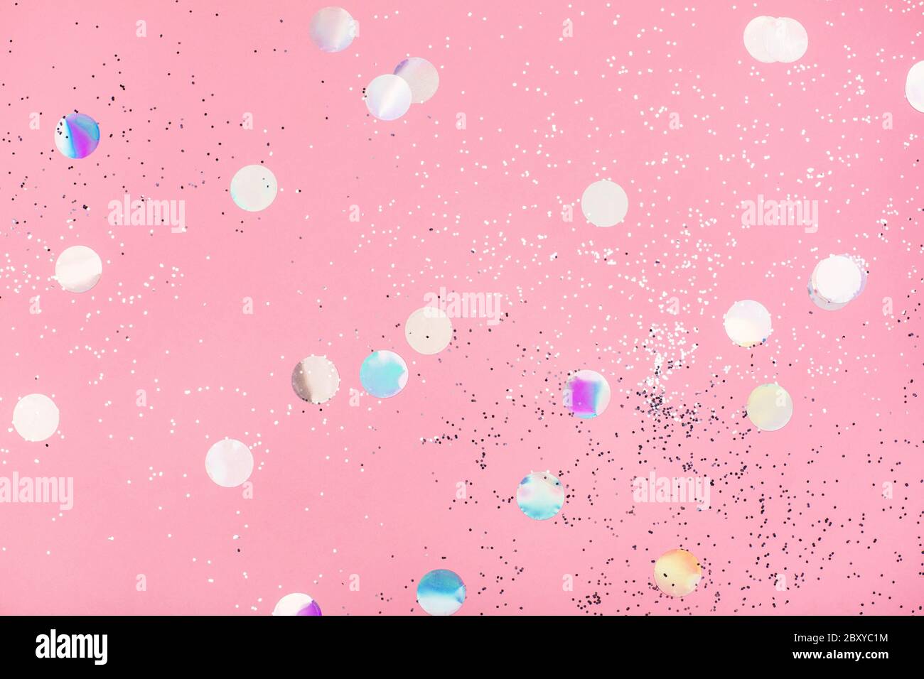 Flying silver holographic confetti on pastel pink background. Festive ...
