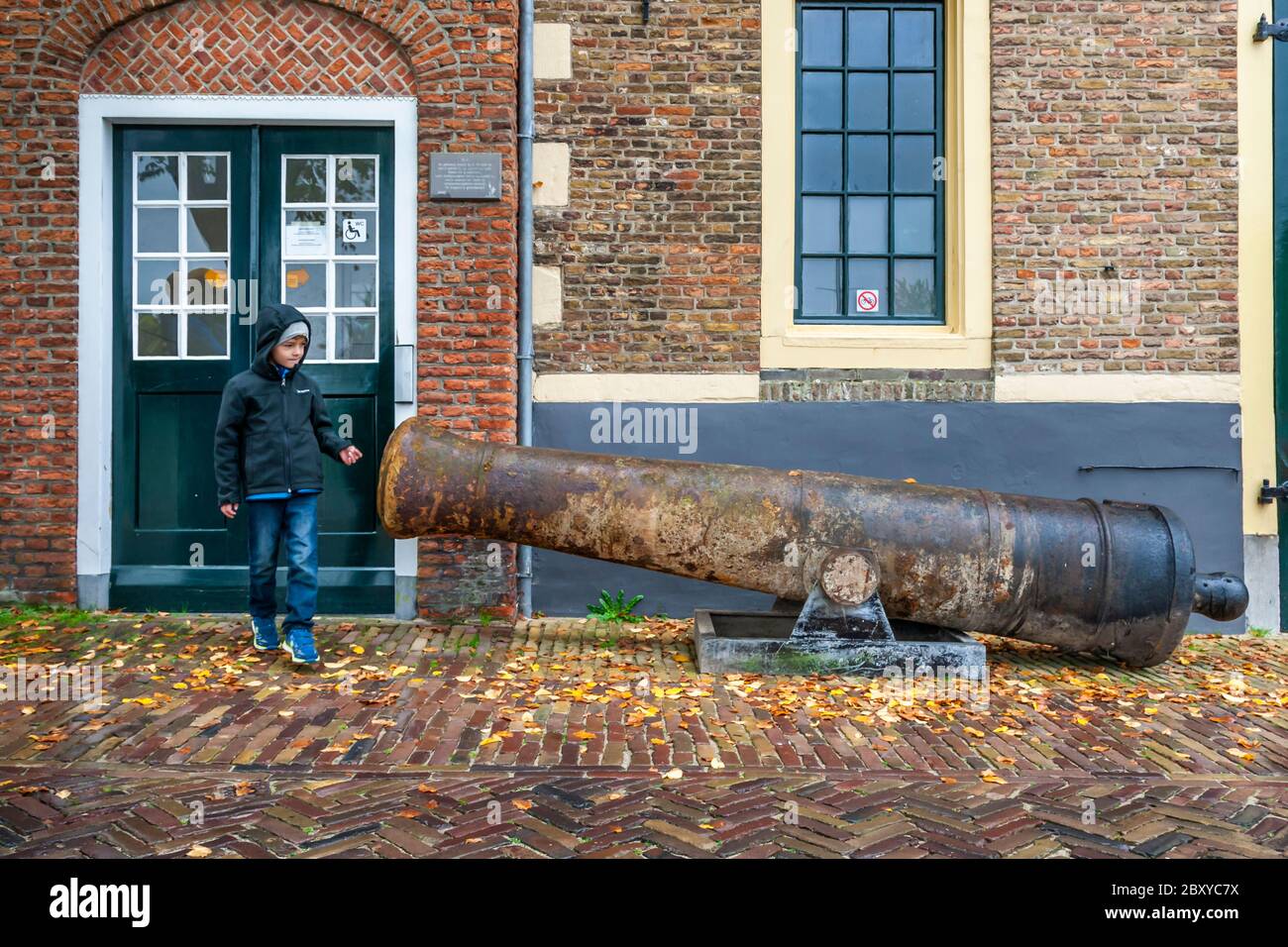 A boy inspects an old cannon in Veere-Oostkapelle, The Netherlands Stock Photo