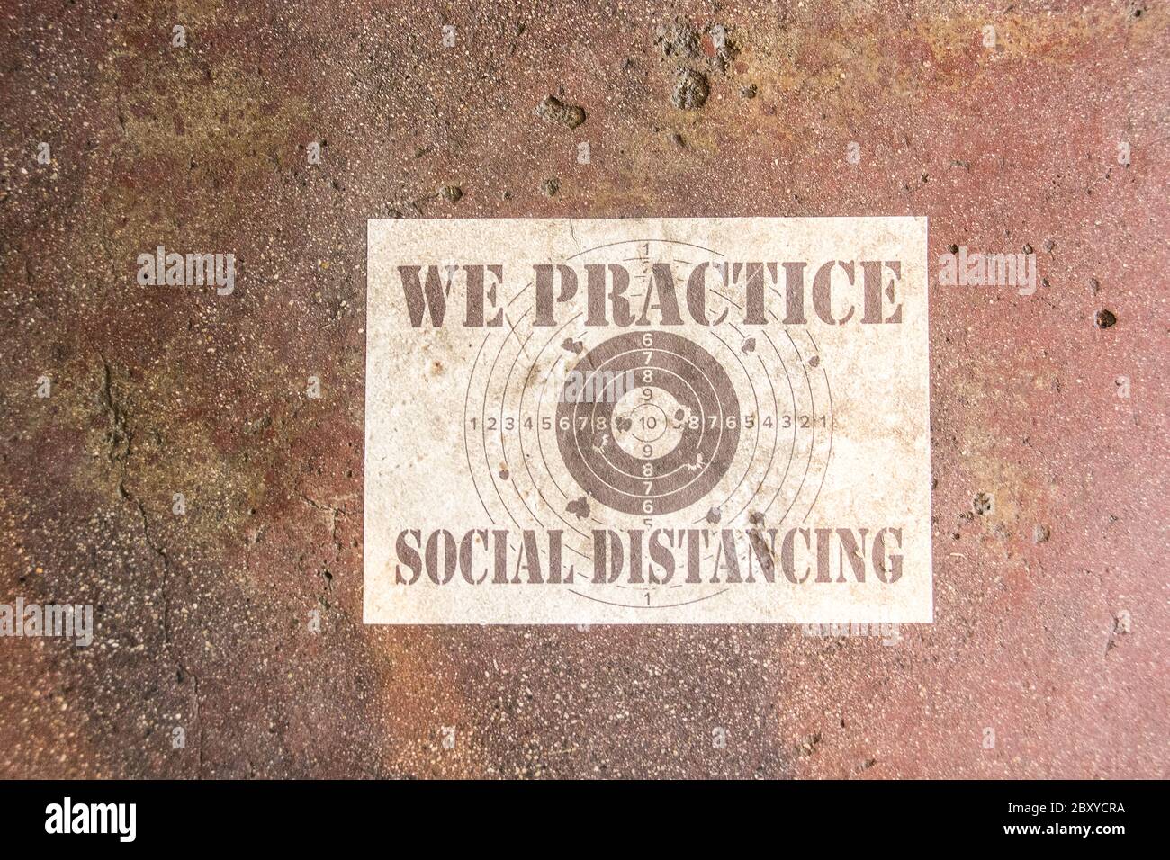 A sign posted on the floor of an eating establishment stating, 'We practice social distancing.' Stock Photo
