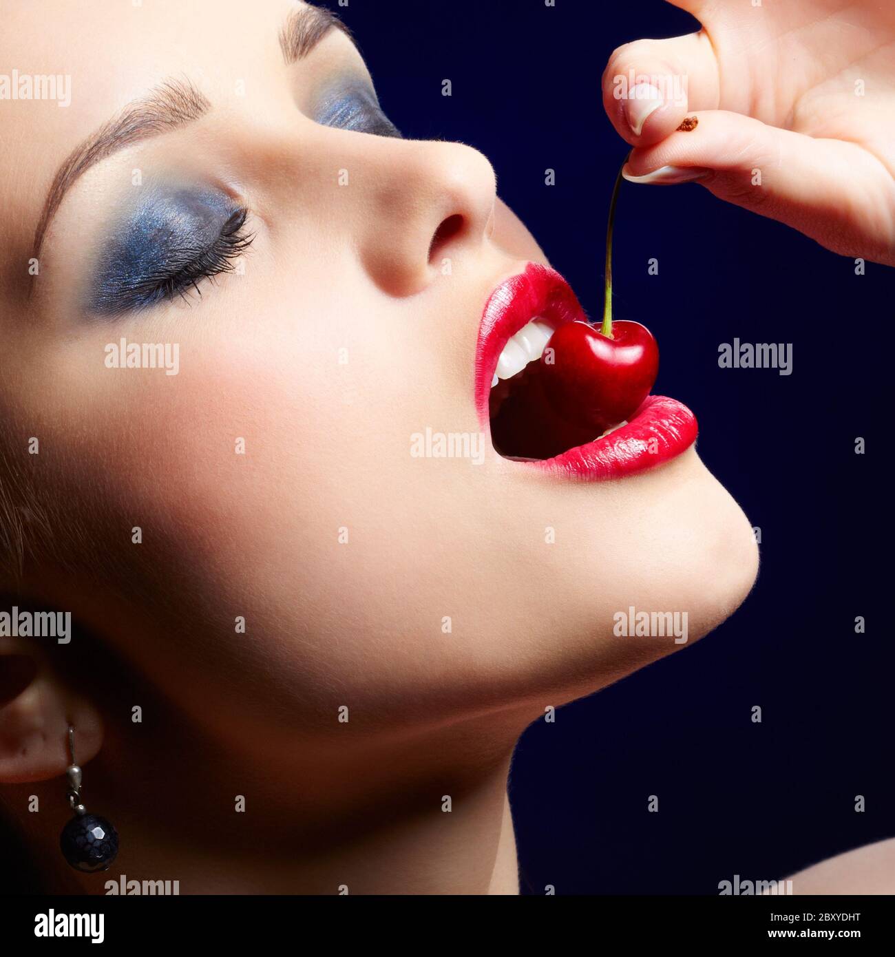brunette woman eating cherry Stock Photo