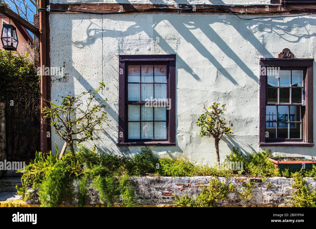 Historical house with stucco walls and wooden windows and trim in sunny