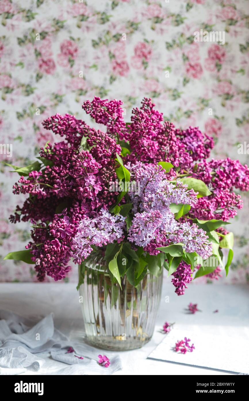 Bouquet of violet lilac in a glass vase. Still life with blooming ...