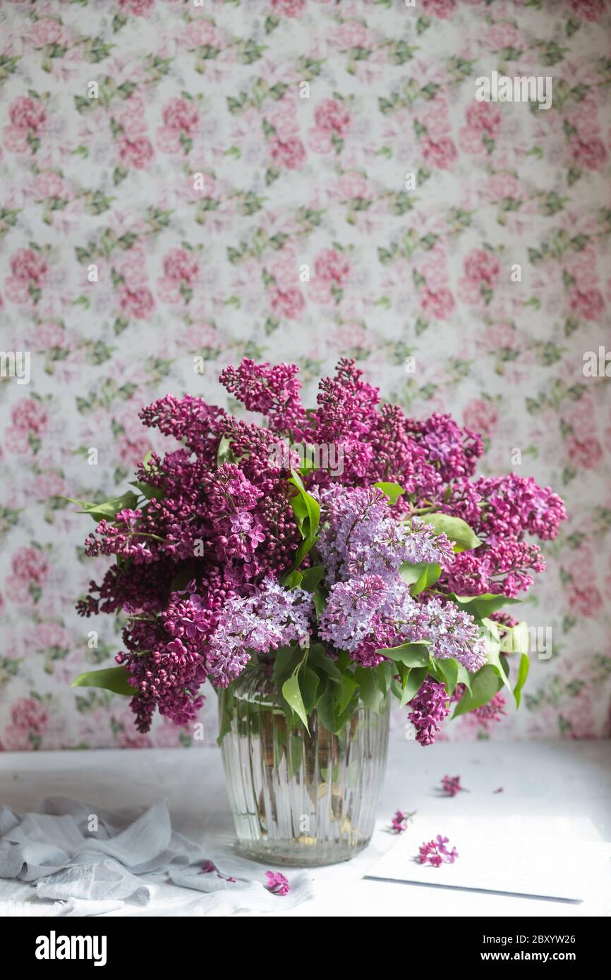 Bouquet of violet lilac in a glass vase. Still life with blooming ...