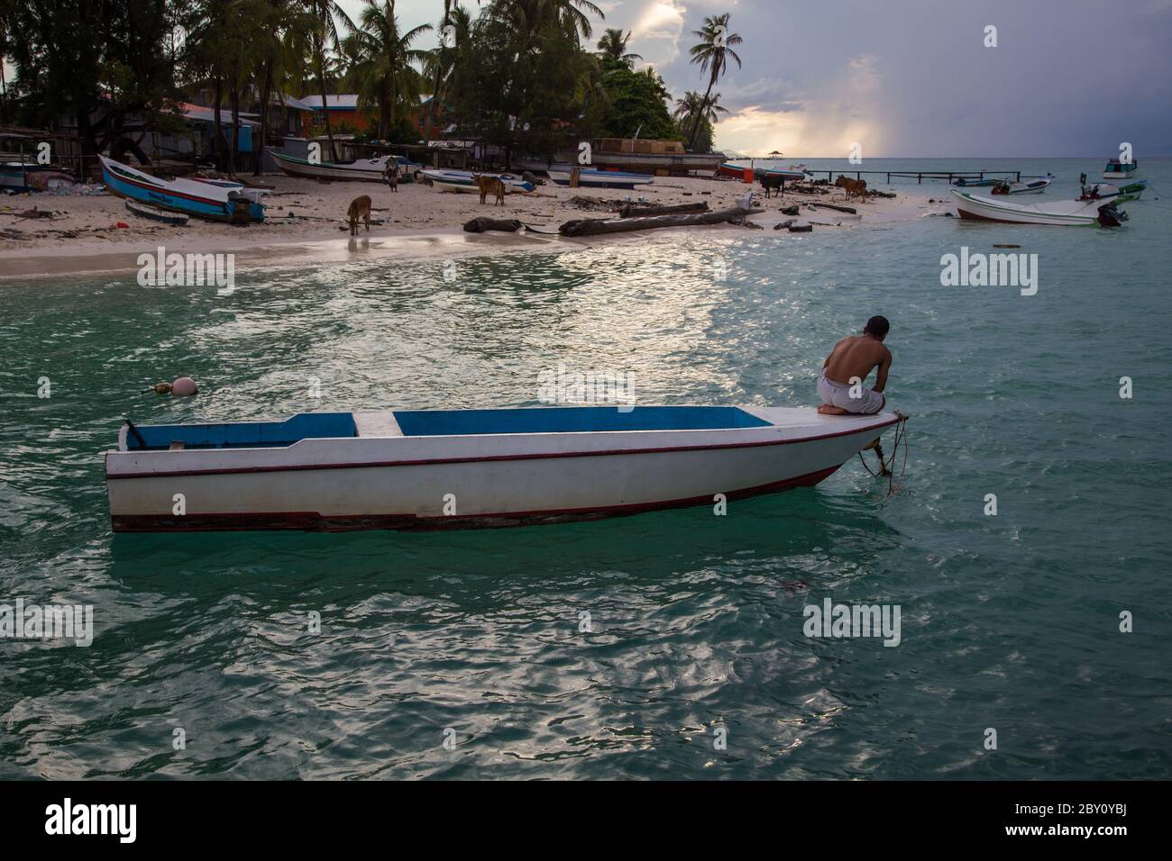 Mantanani Island, Sabah, Malaysia-CIRCA SEPTEMBER, 2017: Unidentified fisherman in a boat trying to pull up boat anchor and ready to go sea to fishing Stock Photo