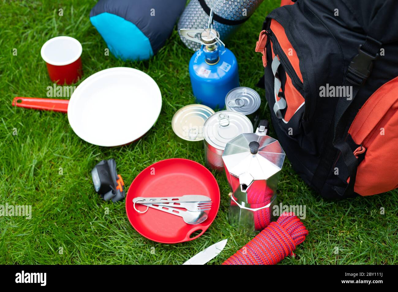 Picture of camping tools on the grass - backpack, tent, gas tank, cans ...