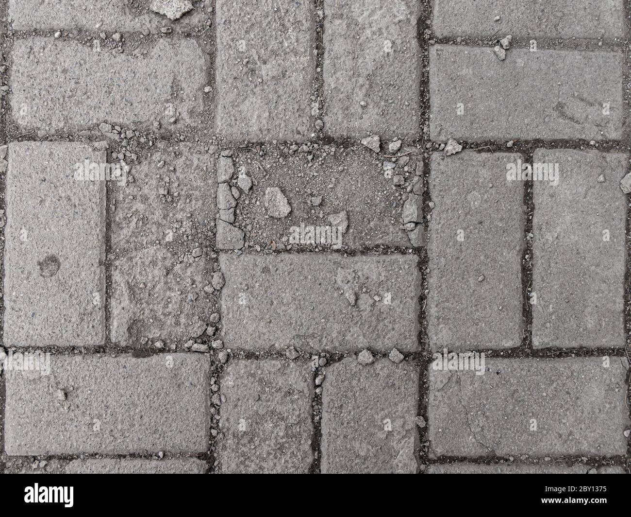 the laid low-quality gray paving slabs with a layered top layer are easily destroyed by external influences Stock Photo