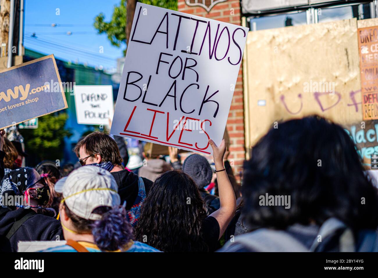 SEATTLE, USA - JUNE 6, 2020: A latin woman holds a sign in a demonstration against racism near a Seattle Police precinct Stock Photo