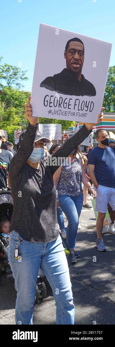 George Floyd Black Lives Matter Protest - Woman Holding George Floyd Sign walking vertical long royalty free stock photograph - Ridgefield Park Bergen Stock Photo