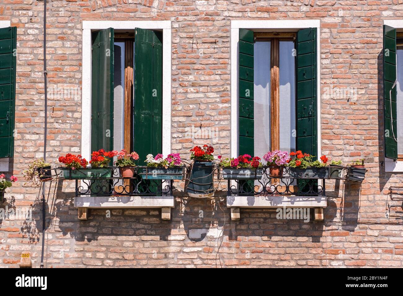 Traditional Italian balconies with perlagonium filled window boxes. Venice, Italy. Stock Photo
