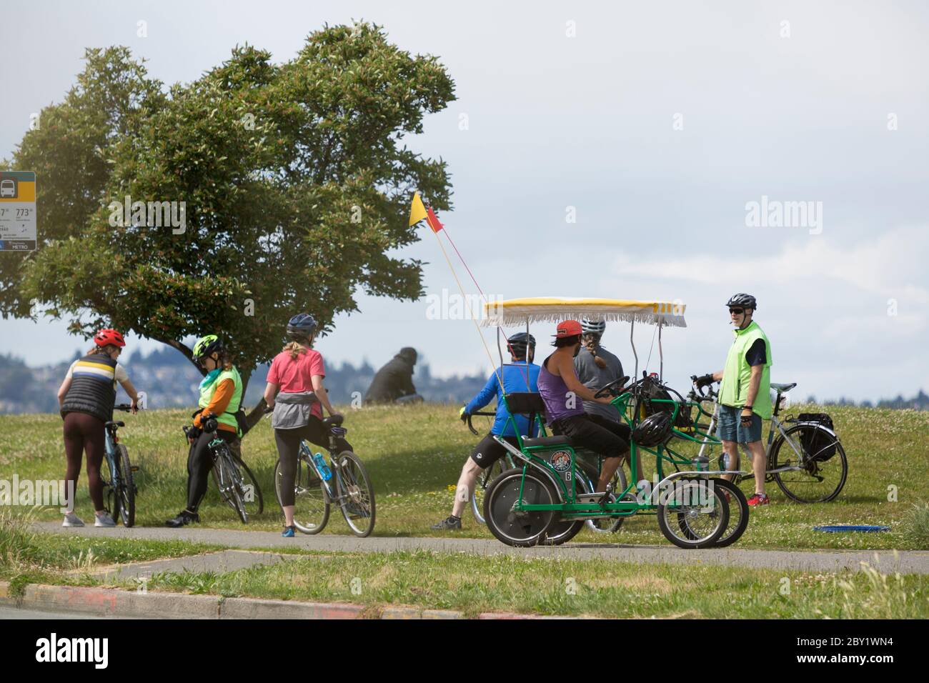 A group of cyclists gather along Alki Trail in Seattle, Washington as coronavirus pandemic restrictions are eased. As of Friday, June 5th, King County is now in modified Phase 1 as part of governor Jay Inslee's Safe Start reopening plan allowing for limited openings of recreational, social and business activities. Stock Photo