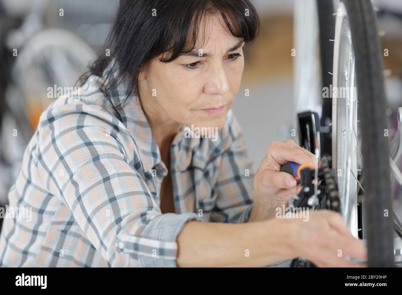 woman is examining bicycle wheel Stock Photo