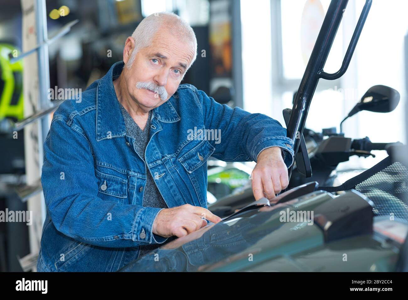 senior man checking motorbike Stock Photo