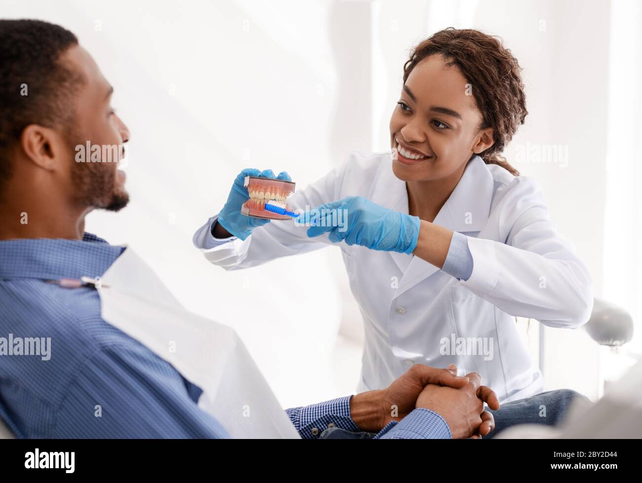 Dentist showing patient how to brush teeth in accurate way Stock Photo Alamy