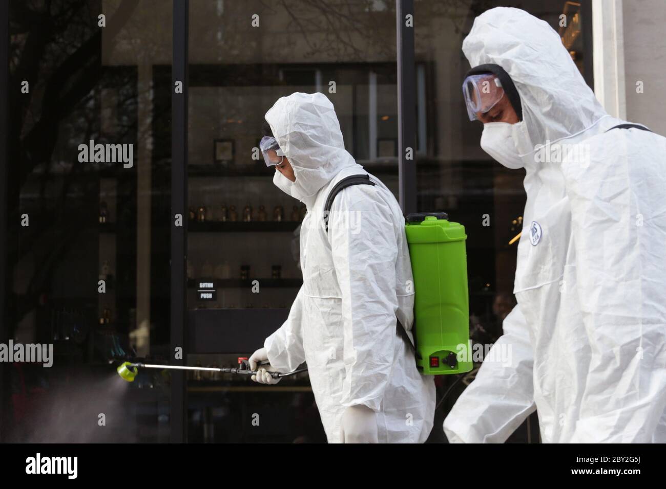 Sofia, Bulgaria - 11 April, 2020: Workers spray disinfectant outside on a street against the spread of coronavirus disease COVID-19. Stock Photo