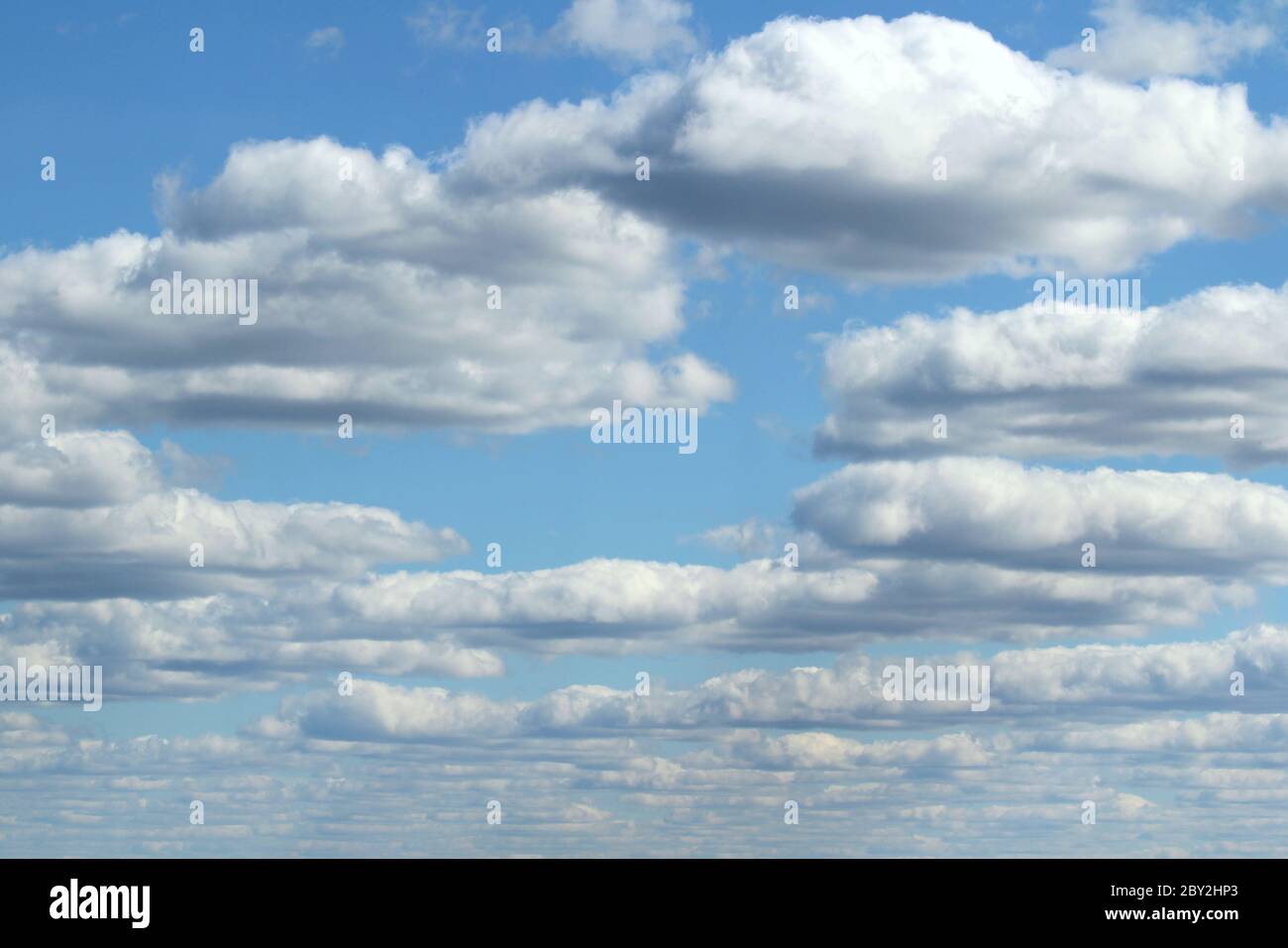 White fluffy clouds on a background of blue sky in summer. The concept ...
