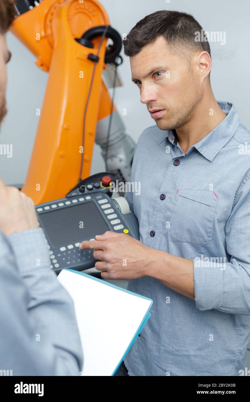 machine operator in production plant checking data Stock Photo
