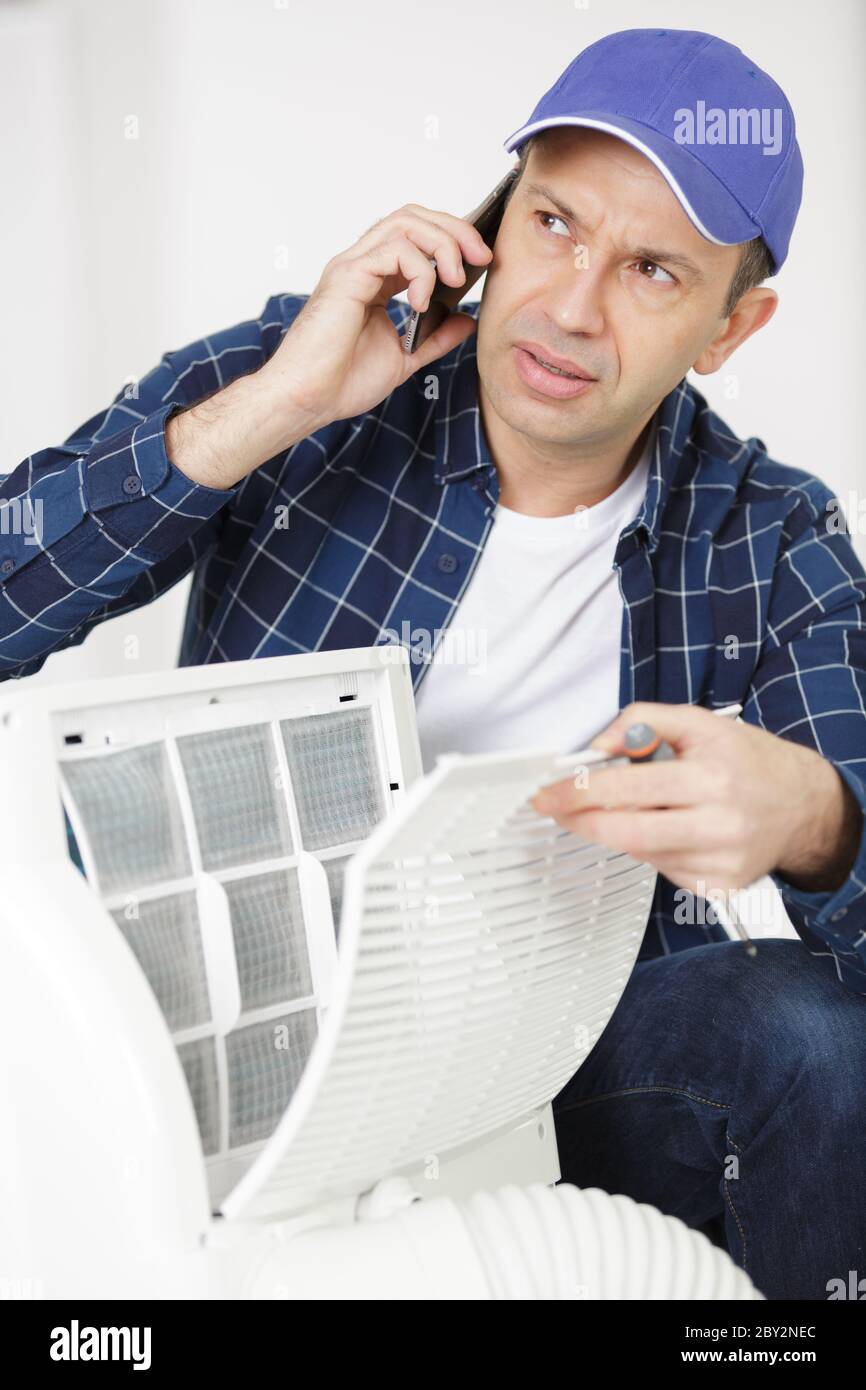 young repairman contractor repairing heating panel Stock Photo
