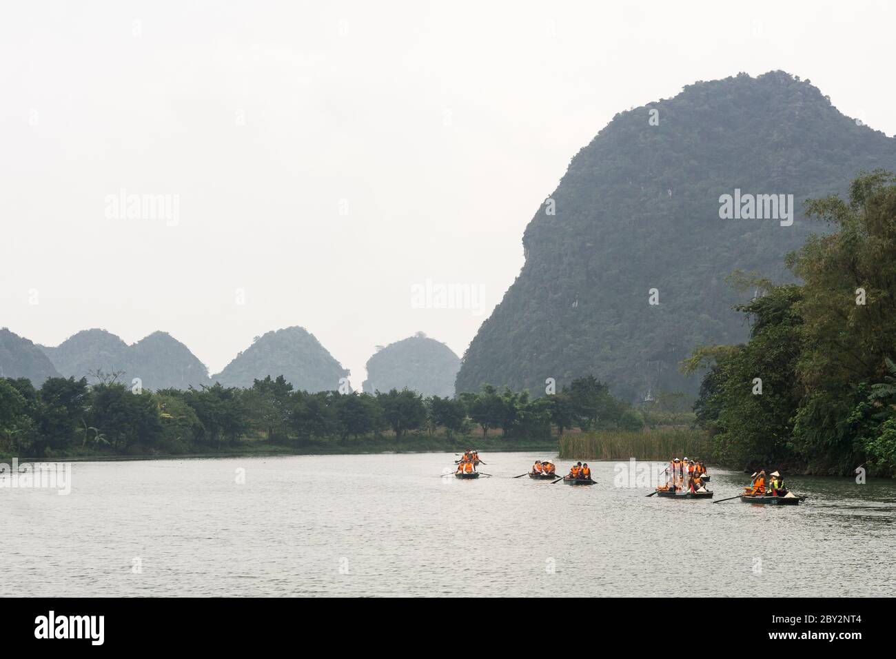 Vietnam Trang An Landscape Complex - Rowboats with tourists enjoying the landscape in Trang An in Ninh Binh Province of North Vietnam. Stock Photo