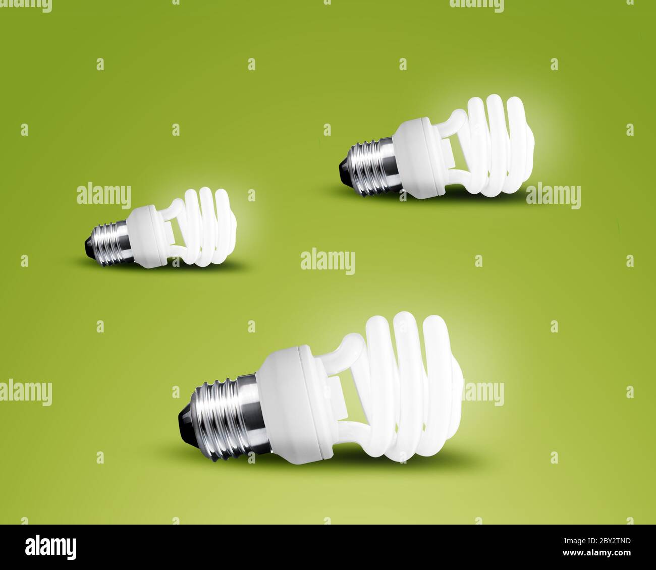 Three glowing Light bulb idea on green background Stock Photo - Alamy