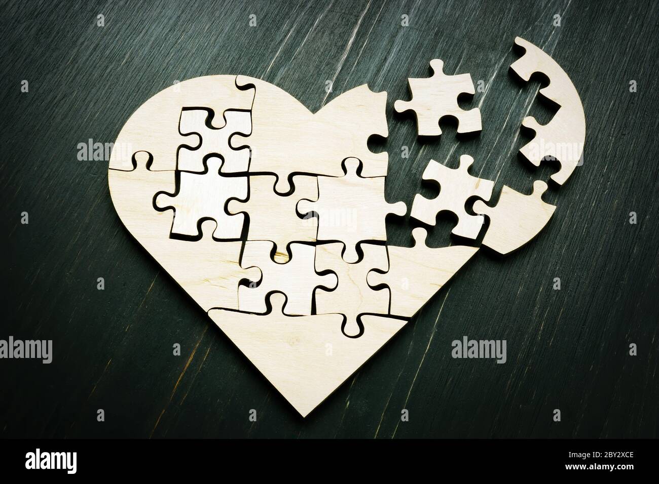 Heart from a broken puzzle with pieces. Symbol of divorce cardiovascular disease. Stock Photo