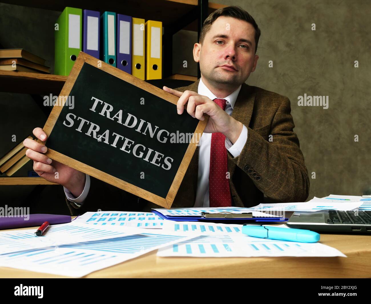 Trader holds plate with inscription Trading Strategies. Stock Photo
