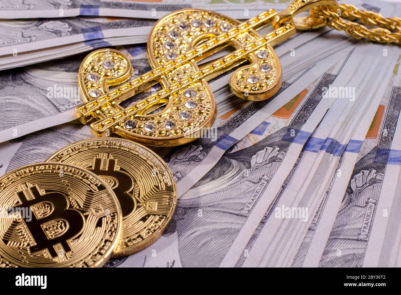 Shiny Gold Dollar Sign Necklace and Physical Bitcoin on a United States  Dollar Bills Stock Photo - Alamy