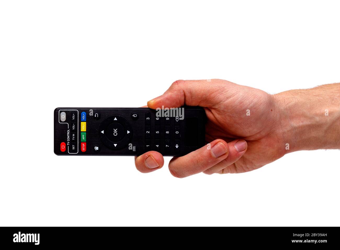 Male hand holding tv remote isolated on white background. Minimalistic concept. Stock Photo