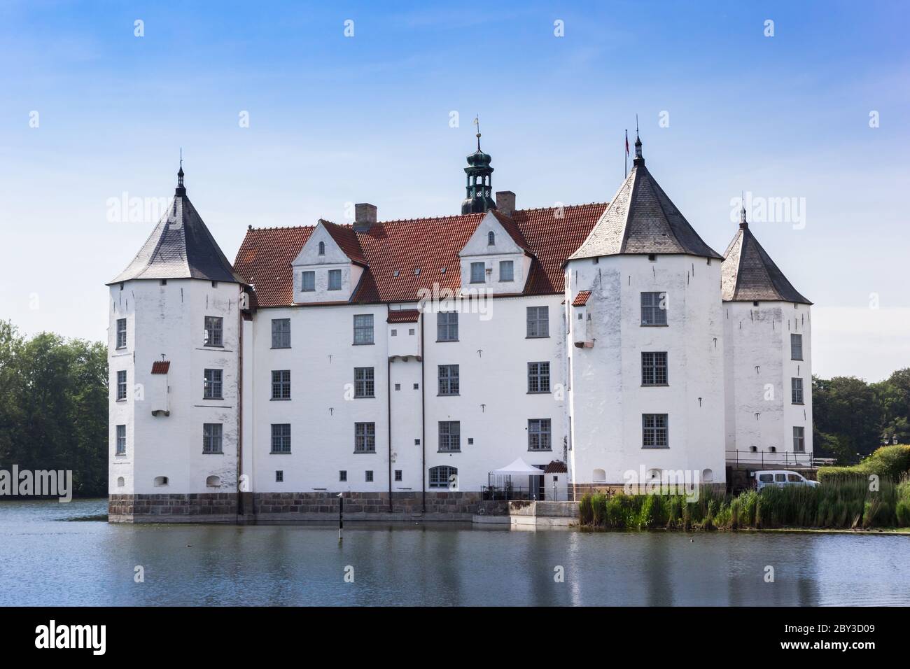 Historic white castle at the lake in Glucksburg, Germany Stock Photo