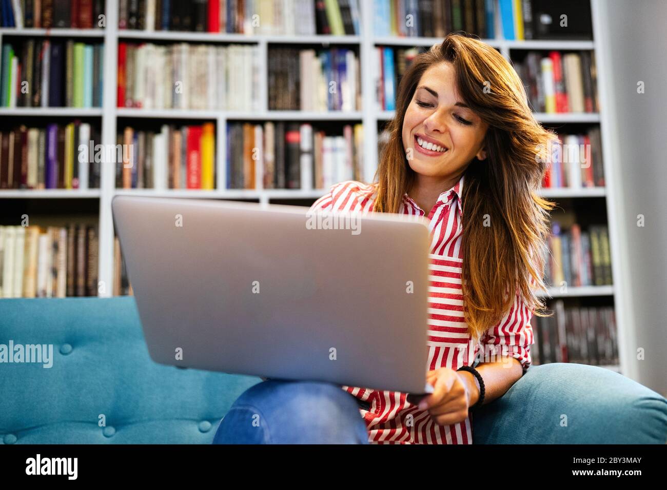 Portrait of happy student woman working on laptop Stock Photo