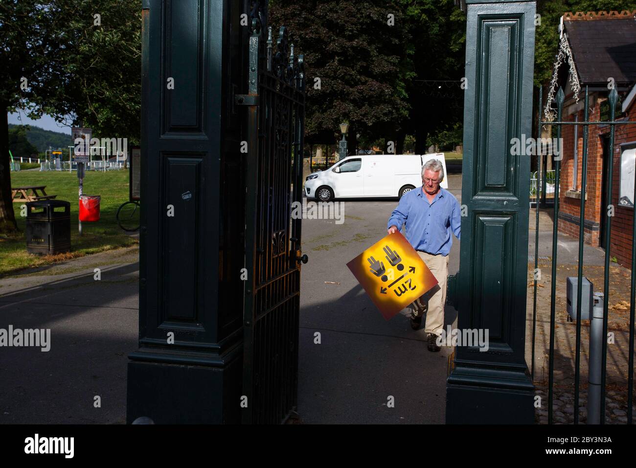 Carmarthen, UK. 9 June, 2020. Adrian Lloyd, Operations Officer for Carmarthen Town Council, prepares to re-open Carmarthen Park by stencilling signs encouraging social distancing at the entrances to the Park. The park has been closed since Lockdown was imposed on the 23rd March 2020. Credit: Gruffydd Ll. Thomas/Alamy Live News Stock Photo