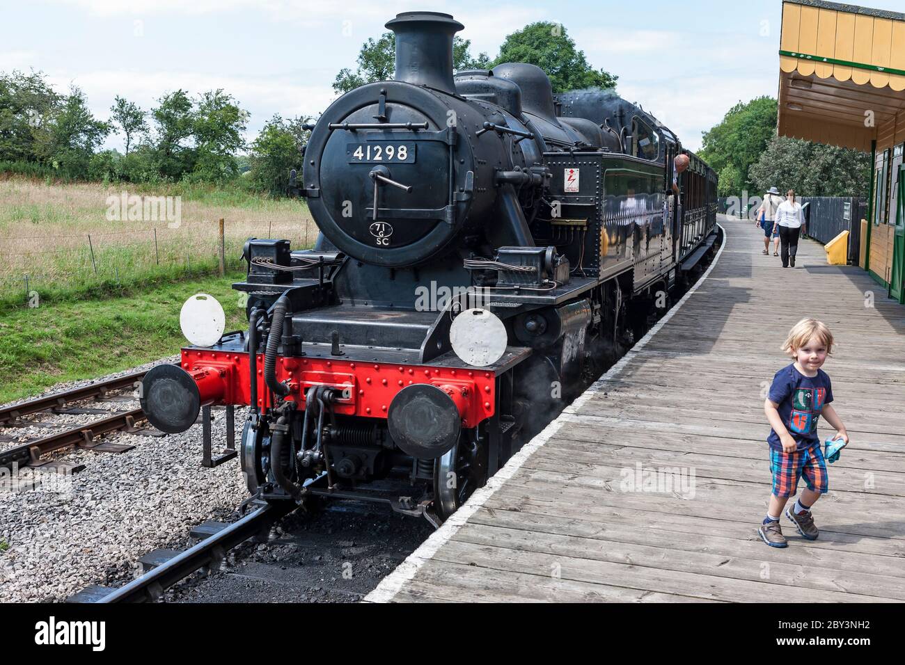 A young railway enthusiast on the platform at Smallbrook Junction on the Isle of Wight Steam Railway, Isle of Wight, England, UK.  MODEL RELEASED Stock Photo