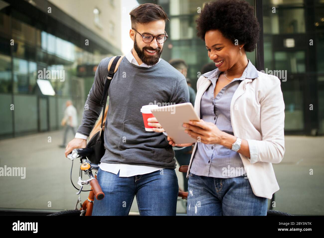 View at young business people talking and smiling outdoors Stock Photo ...