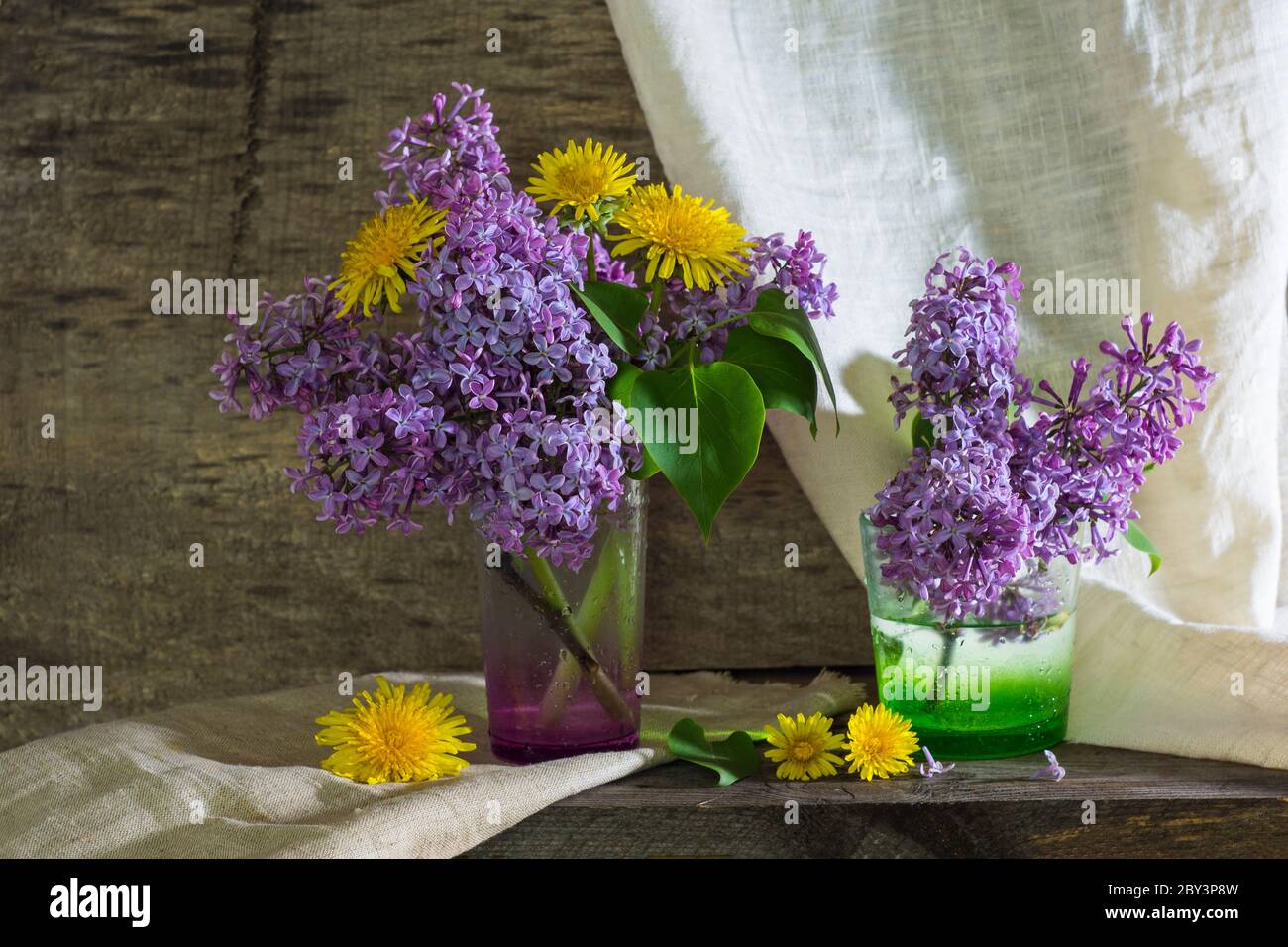 rustic still life with lilac in a glass vase and daisies wooden ...