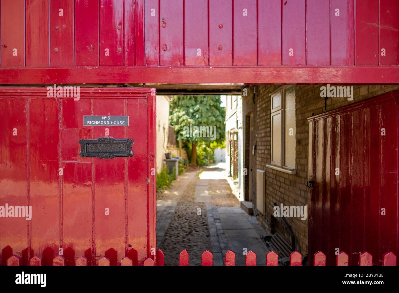Shallow focus of a street-side entrance door showing the house number and rustic letter box. Stock Photo