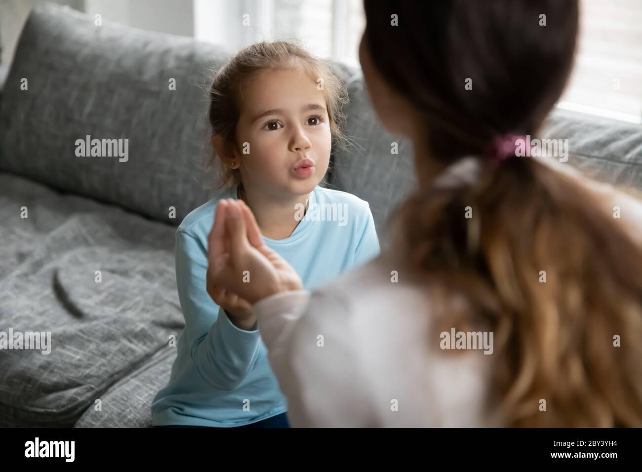 Small disabled girl learn sign language with mom Stock Photo