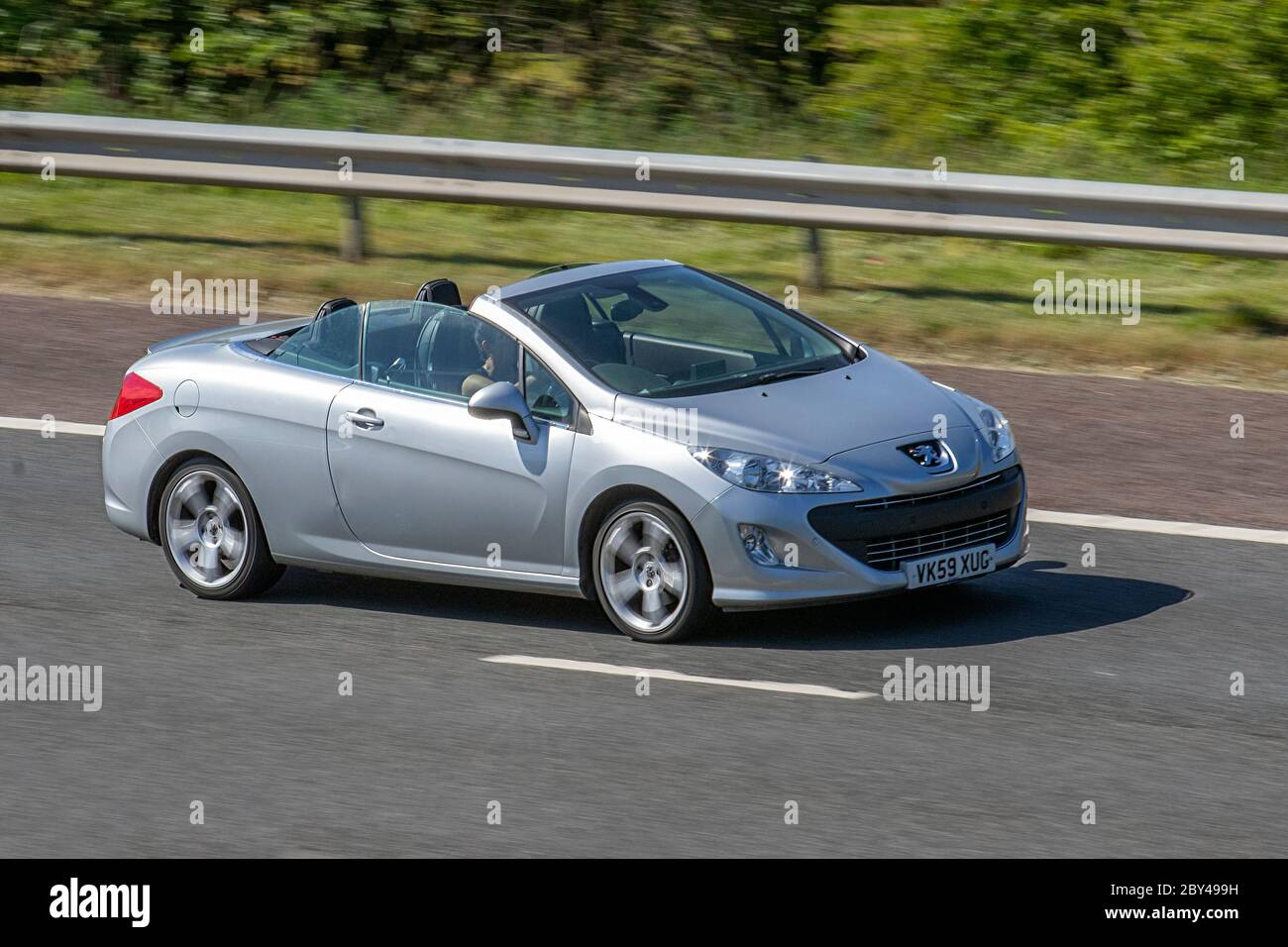 2009 silver Peugeot 308 CC GT HDI cabriolet; Vehicular traffic moving vehicles, cars driving vehicle on UK roads, motors, motoring on the M6 motorway highway Stock Photo
