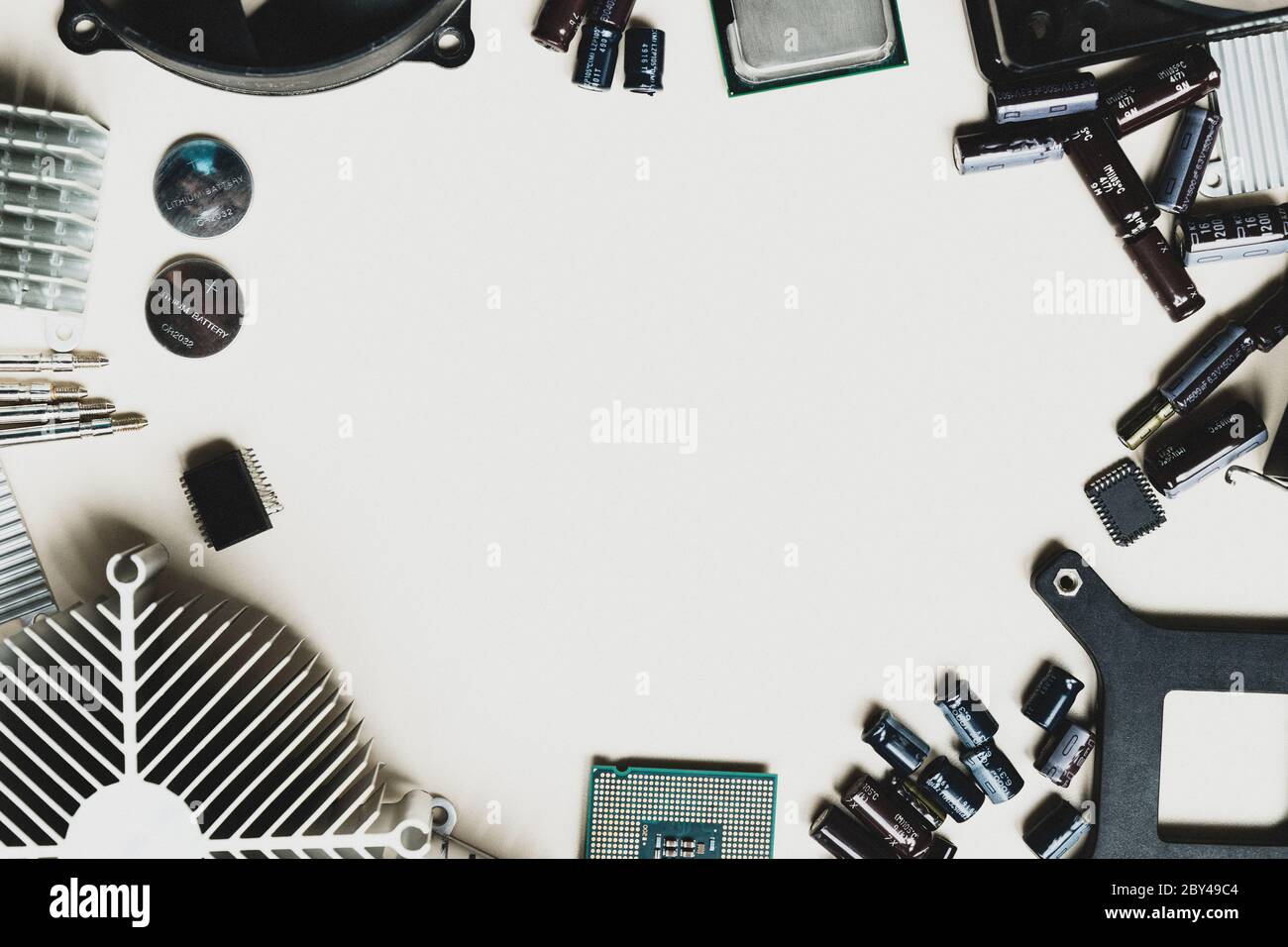 Top view of computer parts with CPU, fan cooler, battery, capacitors