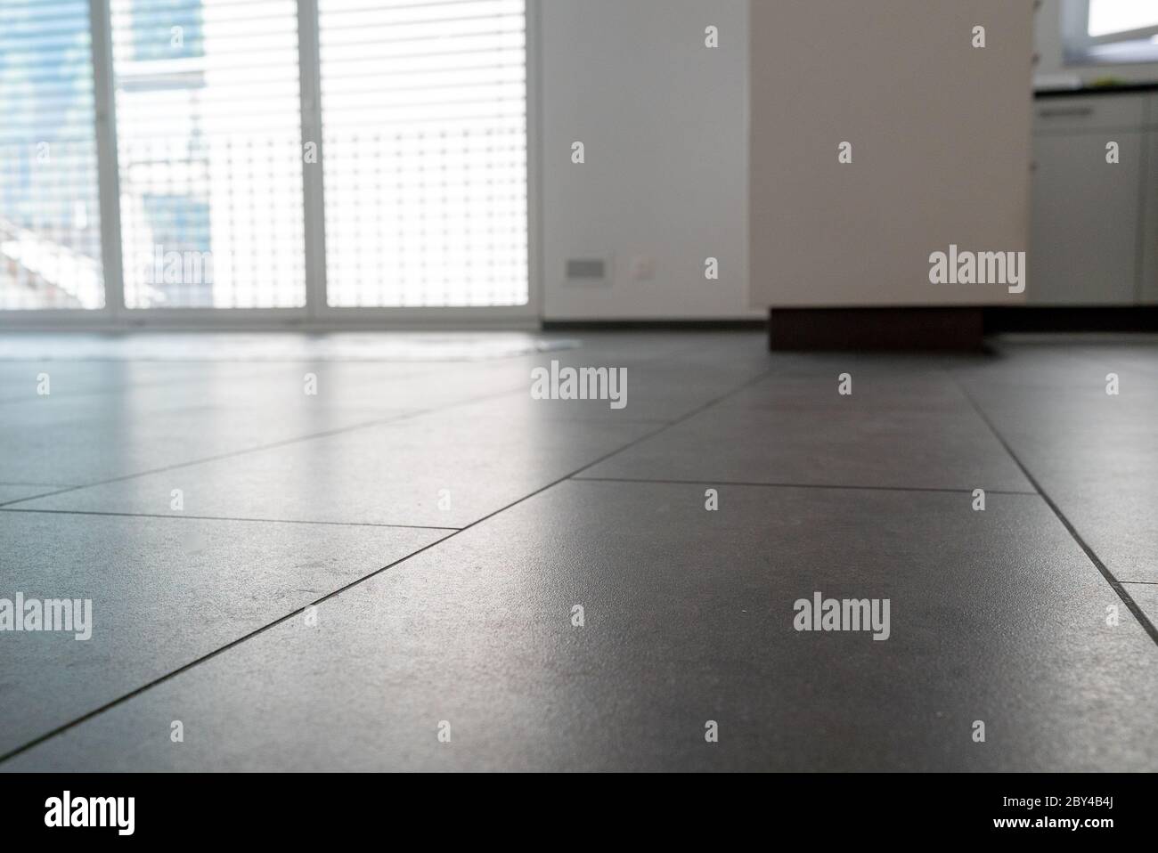 A low angle horizontal view of a new black ceramic tile floor in a ...