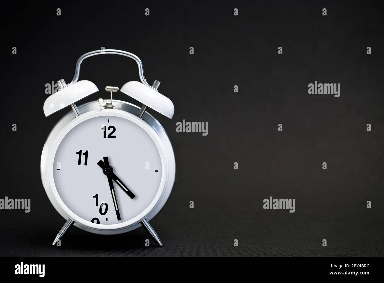 Approaching deadline concept. Classic white double bell alarm clock