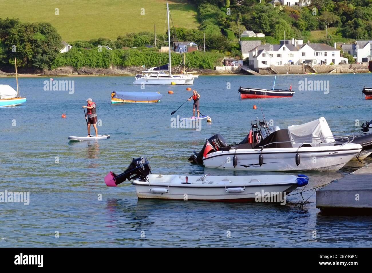 Stand up paddle surfing and paddle boarding in Salcombe Estuary, Devon, England, UK Stock Photo