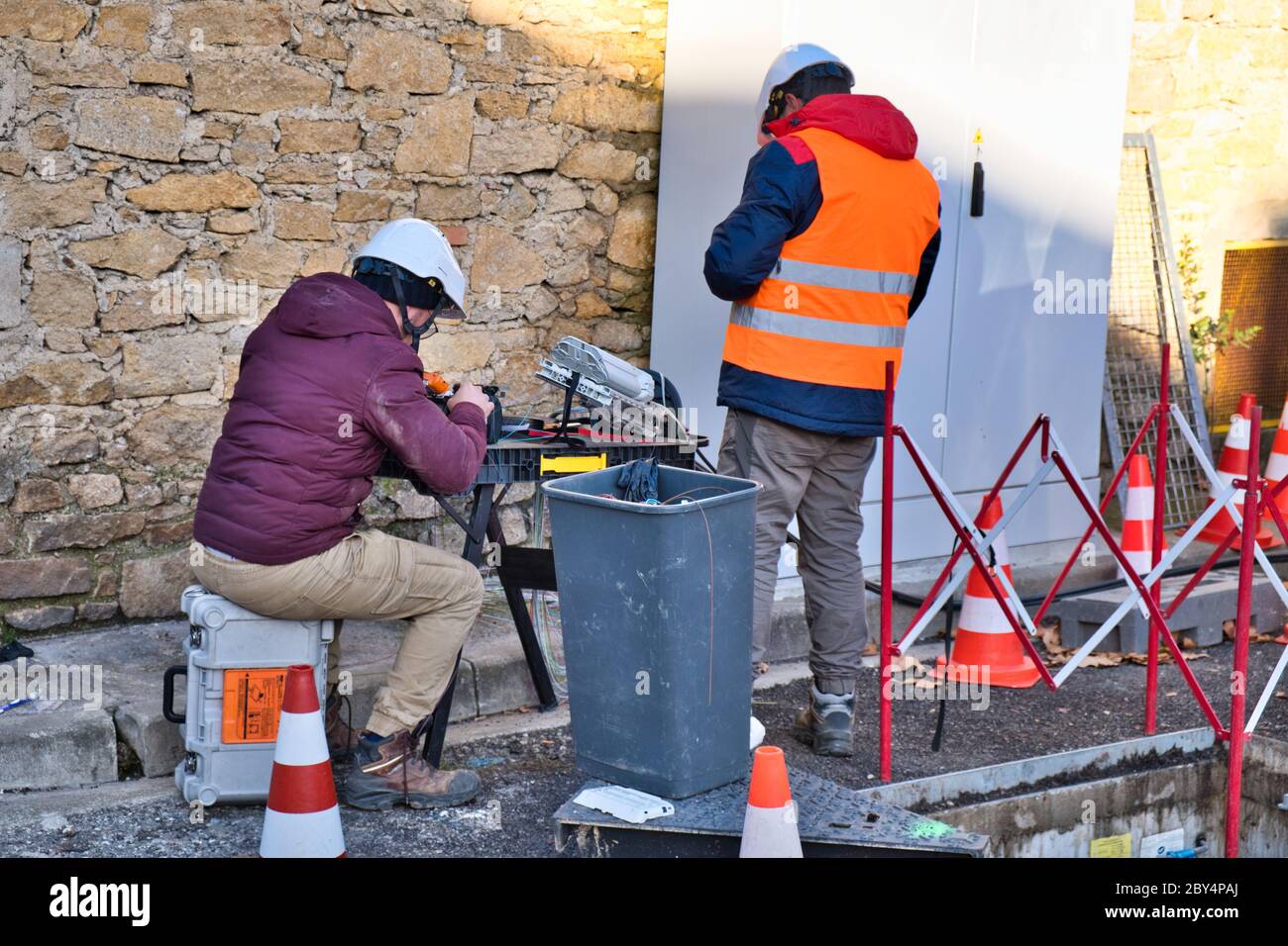 Limoux Aude France 12/10/19 Technicians working in the street installing fibre optic network for high speed internet network. Man operating a fibre co Stock Photo