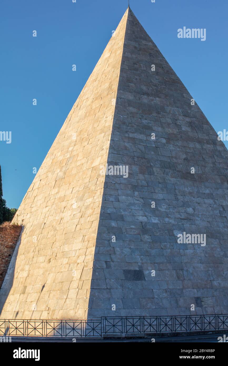 Pyramid of Gaius Cestius, in Piramide, in the evening light. Originally a tomb for a wealthy Roman it was later incorporated into the Aurelian Walls. Stock Photo