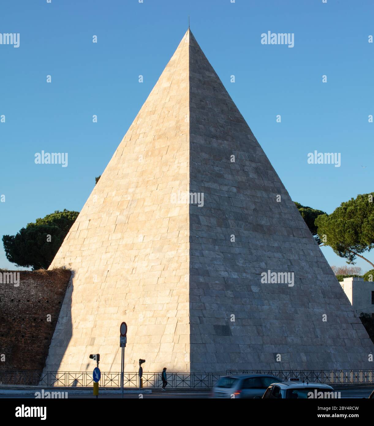Pyramid of Gaius Cestius, in Piramide, in the evening light. Originally a tomb for a wealthy Roman it was later incorporated into the Aurelian Walls. Stock Photo