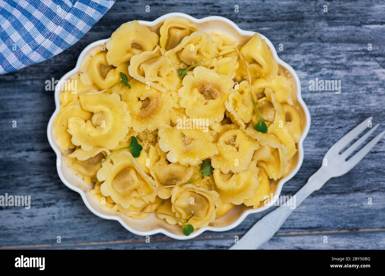 Tortellini Italian stuffed pasta on a plate with cheese and vegetables Stock Photo