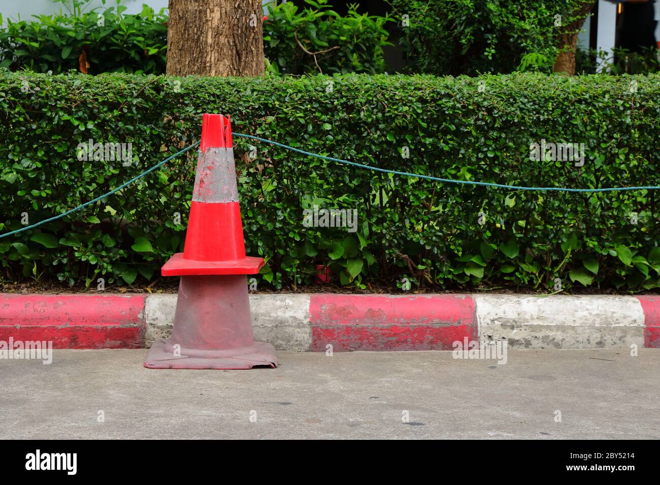 Closeup stack of two traffic cones, the smaller one with brighter color is above the larger with faded color, together we are strong concept Stock Photo