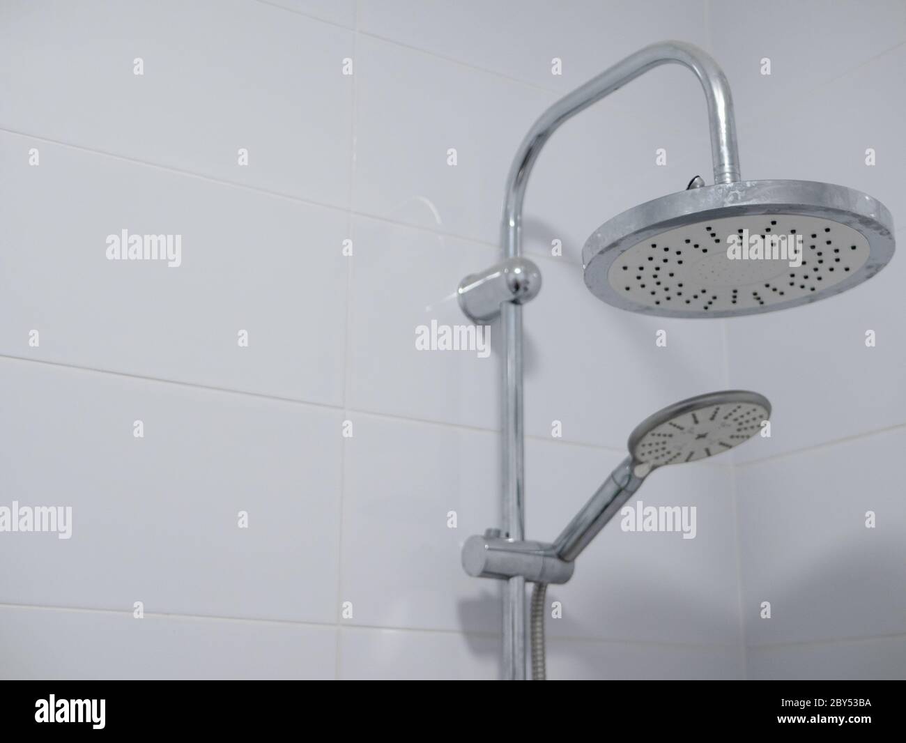 double shower heads with chrome finish in clean bathroom with pure