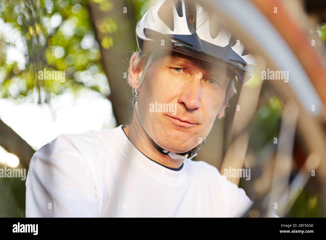 Man with wheel and flat tire repairs his bike Stock Photo